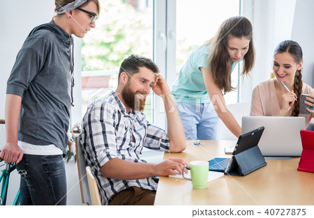 Woman holding a commuter bike while talking with her colleagues 40727875