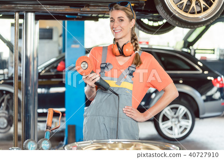 Portrait of a cheerful female auto mechanic wearing safety equipment 40727910