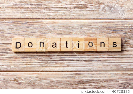 Donation word written on wood block. Donation word written on wood block. 40728325