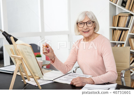 Positive senior woman studying subject 40731601