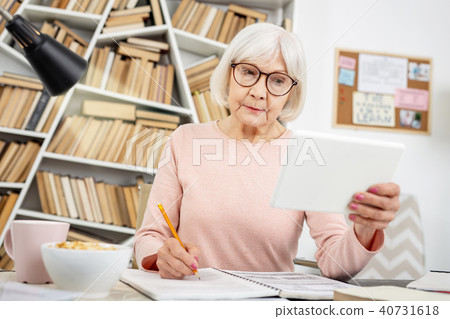 Careful senior woman watching lecture 40731618