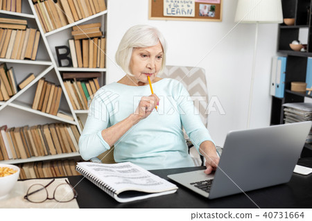 Concentrated mature woman trying freelance 40731664