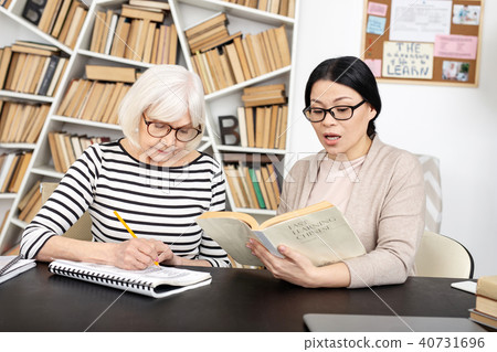 Successful tutor conducting lesson to senior woman Successful tutor conducting lesson to senior woman 40731696