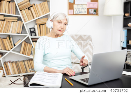 Attentive senior freelancer making online call Attentive senior freelancer making online call 40731702
