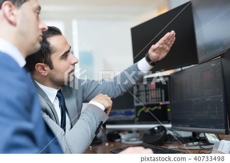 Stock brokers looking at computer screens, trading online. Stock brokers looking at computer screens, trading online. 40733498