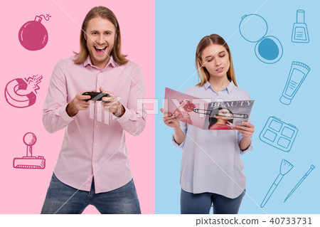 Excited man playing video games and a calm woman reading a magazine 40733731