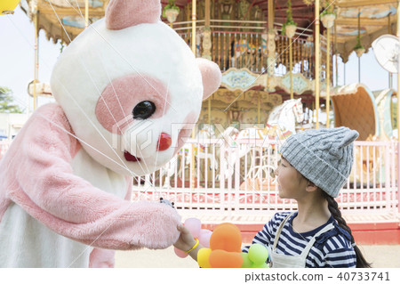 Children shaking hands with their costumes at an amusement park 40733741