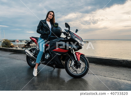Biker girl in a leather jacket on a black and red color motorcycle Biker girl in a leather jacket on a black and red color motorcycle 40733820