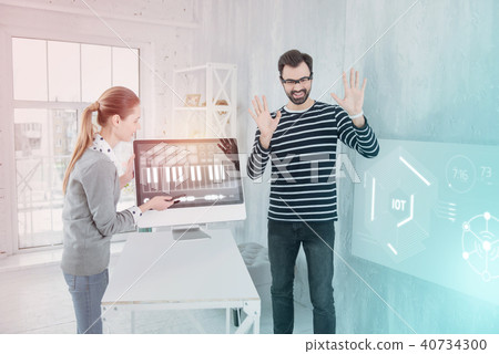 Emotional man putting his hands up while wearing futuristic glasses 40734300