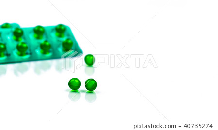 Green round soft capsule pills on blur background 40735274