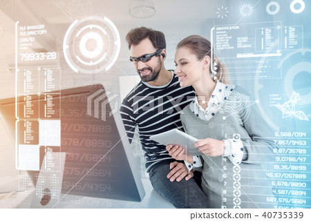 Cheerful programmers looking at the screen of their computer and feeling glad 40735339
