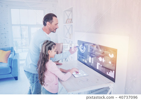 Calm girl using a tablet while her father working with a stylus Calm girl using a tablet while her father working with a stylus 40737096