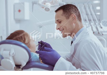 Jolly male dentist checking teeth 40737798