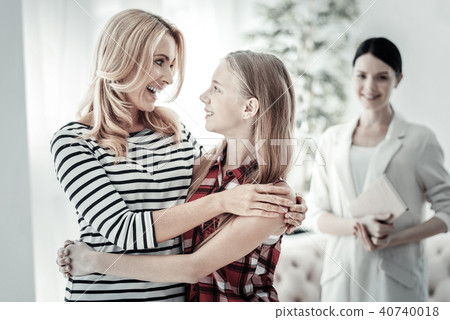 Happy pleasant mother smiling and hugging her daughter. Happy pleasant mother smiling and hugging her daughter. 40740018