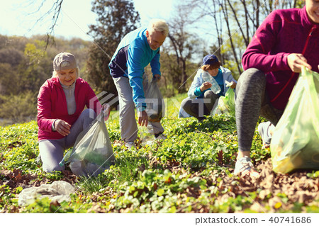 Happy volunteers gathering litter in the forest 40741686