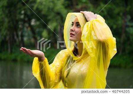 Young happy woman in yellow raincoat Young happy woman in yellow raincoat 40744205