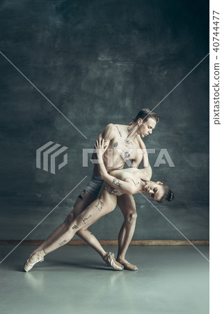 The young modern ballet dancers posing on gray studio background 40744477