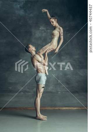 The young modern ballet dancers posing on gray studio background 40744487