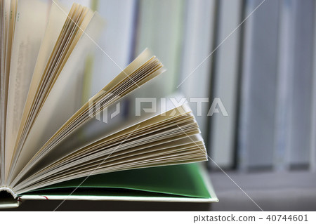 Open book, stack of hardback books on table. Top view. 40744601