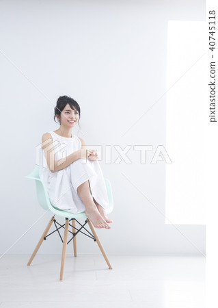 A young woman sitting on a chair A young woman sitting on a chair 40745118