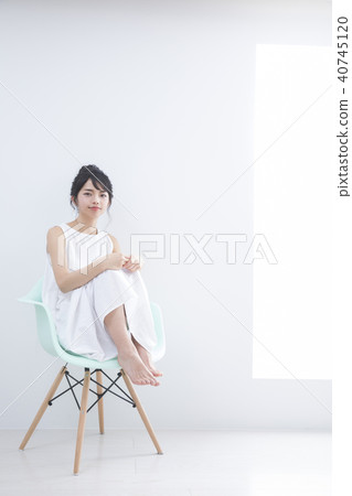 A young woman sitting on a chair A young woman sitting on a chair 40745120