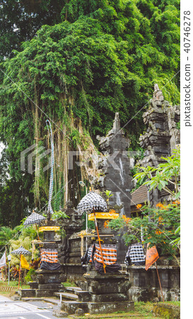 Bali temple entrance with guardian statue and Huge ancient Banyan tree in background. Indonesia 40746278