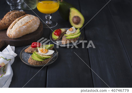 Tasty and juice , sandwich with avocado, tomato and poached egg on wooden chopping board, close up, Tasty and juice , sandwich with avocado, tomato and poached egg on wooden chopping board, close up, 40746779