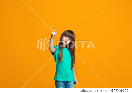 Beautiful female half-length portrait on orange studio backgroud. The young emotional teen girl 40749062
