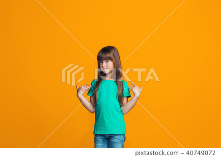 The happy teen girl standing and smiling against pink background. The happy teen girl standing and smiling against pink background. 40749072