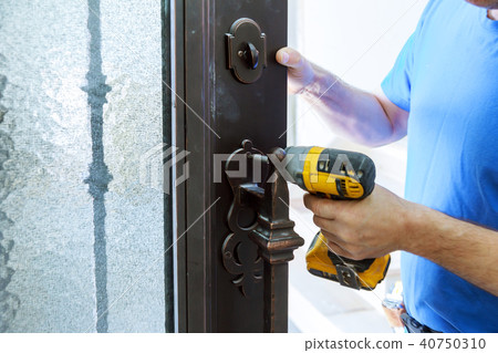 Male handyman carpenter at interior metal door 40750310