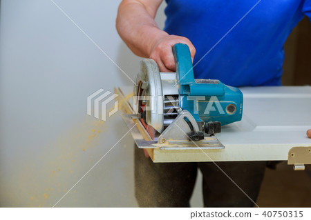 man using a circular saw for cutting wood door man using a circular saw for cutting wood door 40750315