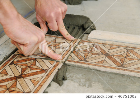 Worker putting tiles on the floor. Worker putting tiles on the floor. 40751002