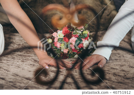 Hands of the bride and groom on a flower background Hands of the bride and groom on a flower background 40751912