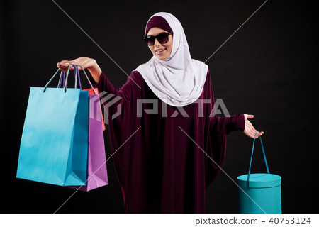 Arab woman in hijab and sunglasses holds paper 40753124