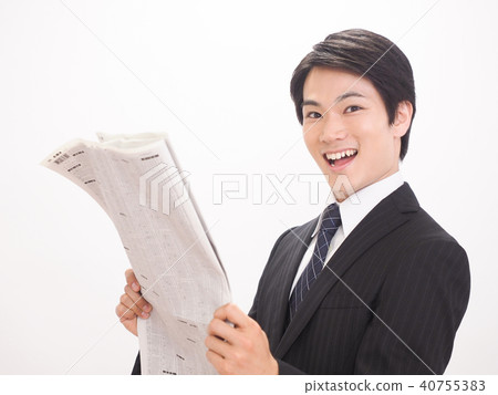 Laughing businessman looking at newspaper stock column 40755383