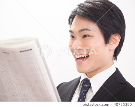Laughing businessman looking at newspaper stock column Laughing businessman looking at newspaper stock column 40755390