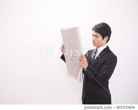 Businessman looking at newspaper stock column Businessman looking at newspaper stock column 40755404