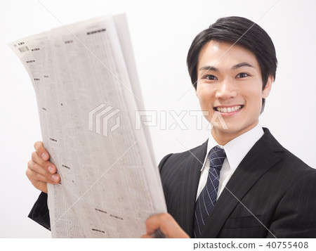 Laughing businessman looking at newspaper stock column Laughing businessman looking at newspaper stock column 40755408