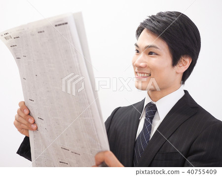 Laughing businessman looking at newspaper stock column Laughing businessman looking at newspaper stock column 40755409