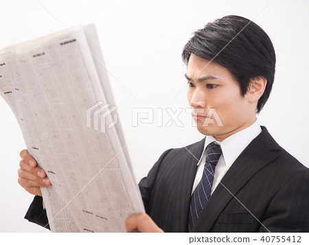 Businessman worried about looking at stock section of newspaper 40755412