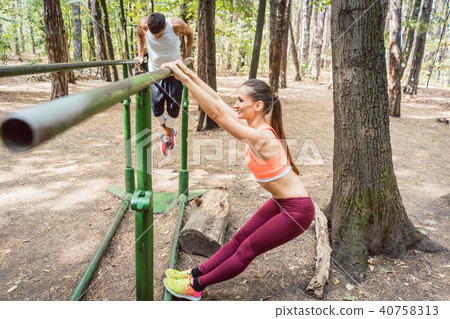 Couple doing full fitness workout in outdoor gym 40758313