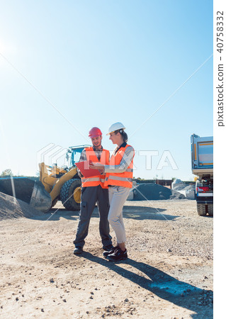 Worker and engineer on earthworks construction site planning Worker and engineer on earthworks construction site planning 40758332