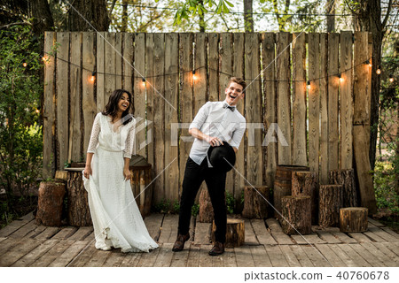 Merry happy young couple have fun near a wooden installation. Merry happy young couple have fun near a wooden installation. 40760678