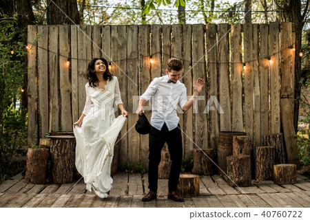 Merry happy young couple have fun near a wooden installation. 40760722