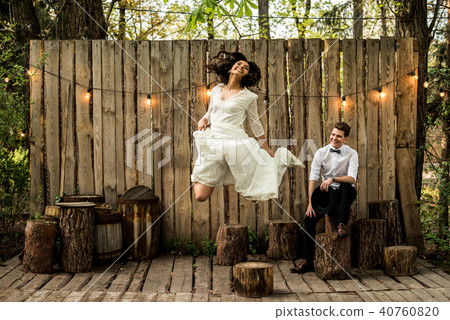 Merry happy young couple have fun near a wooden installation. Merry happy young couple have fun near a wooden installation. 40760820