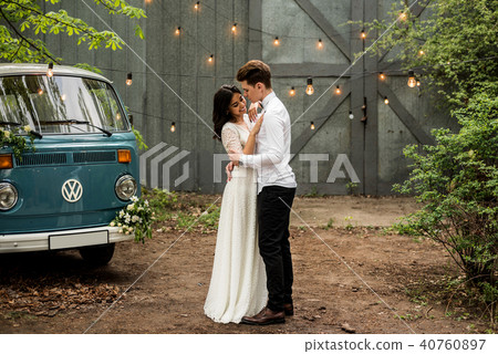 Merry happy young couple hugging near a retro bus Merry happy young couple hugging near a retro bus 40760897