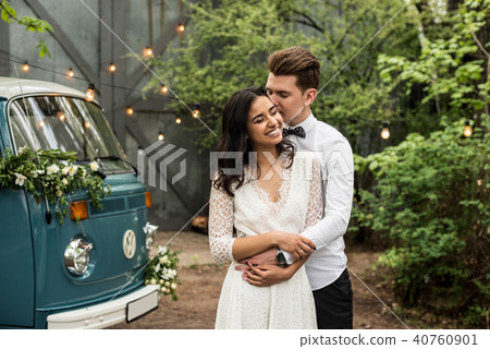 Merry happy young couple hugging near a retro bus 40760901