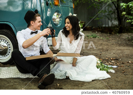 Cheerful happy young couple eat and drink near retro-minibus. Close-up. 40760959
