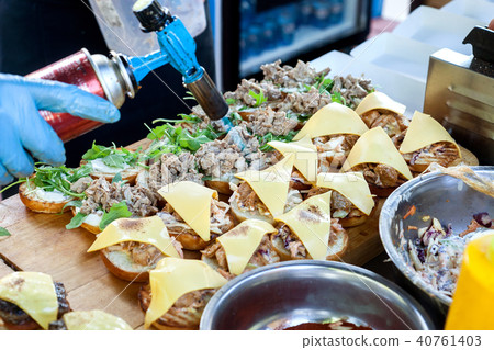 Chef melts cheese with torch while cooking burgers 40761403