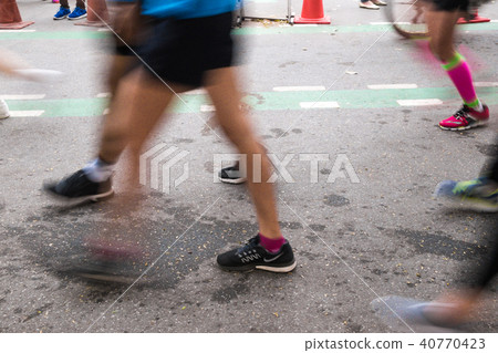 Blurred leg movement marathon running on road 40770423
